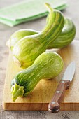 Striped squash on a chopping board with a knife