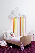 Child's bedroom with child's bed & cloud with ribbon rain decorating wall