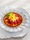Sour cream tartlet with raspberries and passion fruit granita