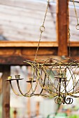 An Antique Candle Chandelier Hanging in a Greenhouse