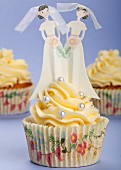 Hochzeits-Cupcakes mit Buttercreme, Silberperlen und Brautfiguren