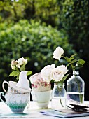 Flowers in vintage bottles with teacups