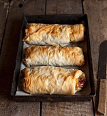 Three vegetable strudels in an old baking tray