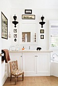 Badezimmer mit Waschtisch in Weiß, Badspiegel & kleinen Bildern & Konsolen als Wanddeko