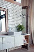 Washstand with white base cabinet on metal legs against tiled wall