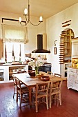 Rustic dining area in spacious kitchen-dining room; collection of rolling pins in arched doorway