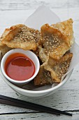 Deep-fried pastry parcels with sesame seeds and chilli sauce (Asia)