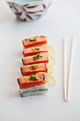 Oshi sushi with seared salmon, sliced spring onions (negi) and lemons (Japan)