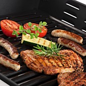 Pork steaks, sausages and vegetables on the grill