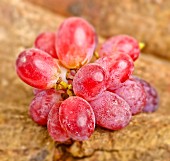 Rosé wine grapes on a wooden surface
