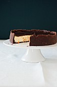 Cheesecake with oranges and chocolate on a cake stand