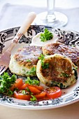 Potato cakes with spinach filling, tomato salad and parsley