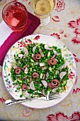 Pea salad with radishes and roast beef rolls