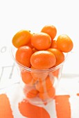 Mehrere Kumquats in einem Glas