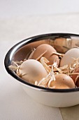 Frische Eier mit Stroh in einer Schüssel