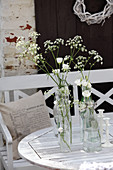 Wildflowers and eustomas in old swing-top bottles on table