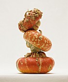 Three turban squash stacked on on top of the other
