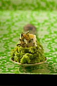 Pea purée on a spoon with butter and dried tarragon