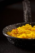 Vanilla risotto with saffron strands in a frying pan