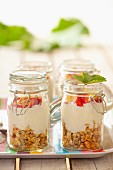 Muesli with oats, yoghurt, strawberries and flaked almonds, in jars
