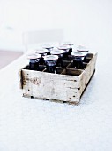 Several bottles of home-made elderberry juice in a wooden box
