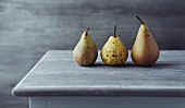 still life with three autumn pears on an old table