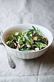 bowl of freshly prepared leaf salad with avocado, walnuts and goat cheese