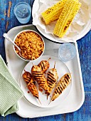 Grilled chicken skewers with couscous and corn on the cob