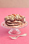 Chocolate meringue layer cake with chocolate cream and nuts