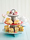 A tiered cake stand with petit fours, Battenburg cake and Victoria Sponge cake (England)
