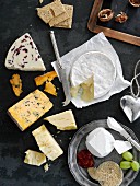Assorted varieties of cheese with crackers, walnuts and grapes