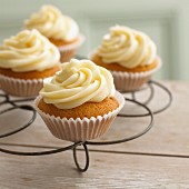 Cupcakes with vanilla cream on a cooling rack