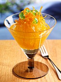 Glasierte Orange mit kandierten Orangenzesten und grünen Kirschen im Stielglas