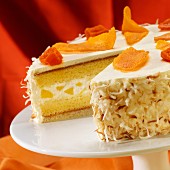 Pineapple Cream Cake Topped with Dried Mango and Papaya with Toasted Coconut; Slice Removed