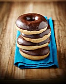 Four doughnuts with chocolate glaze, stacked