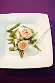 Steamed sole and salmon rolls on green vegetables with a foam sauce