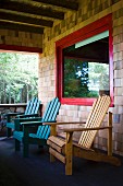 The porch of an Adirondacks cabin with Adirondack chairs