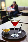 Cocktail mit Gin, Tonic Water, Himbeersirup und Rosmarinzweig, Nachos