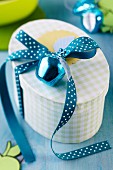 Gift box with apple bauble and polka-dot ribbon
