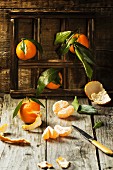 Fresh tangerines with leaves on old wooden table