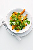 Lamb's lettuce with fried squash, oranges and pumpkin seeds