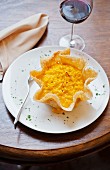 Saffron risotto in a parmesan basket and a glass of red wine