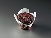 Chocolate muffin wrapped in baking parchment