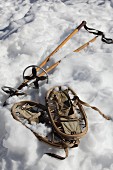 Vintage Schneeschuhe und Ski-Stöcke im Schnee liegend