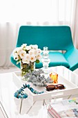 Crystal candlestick on tray table in front of turquoise lounge chair