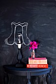 Wall painted with blackboard paint with chalk lampshade drawn around naked lamp bulb on console table