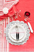 White plate arranged on sheet music place mat and red and white striped tablecloth