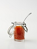 Keta caviar in a jar with a spoon