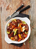 Sausage casserole with peppers, leek and spring onions