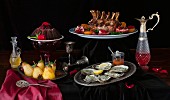 Feastive table with food, crown roast of pork, oysters, chocolate cake and peached pears